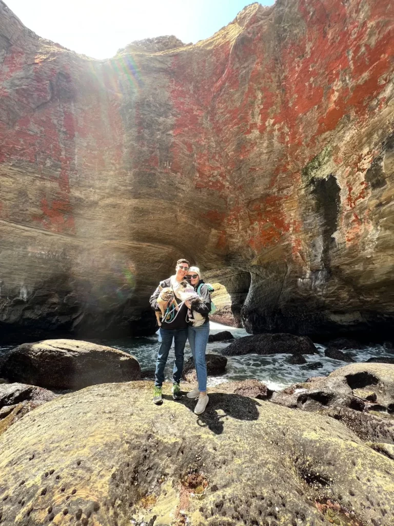 Leira, her husband, and two of her dogs stand inside a swell hole while the tide is out at a beach she grew up going to.