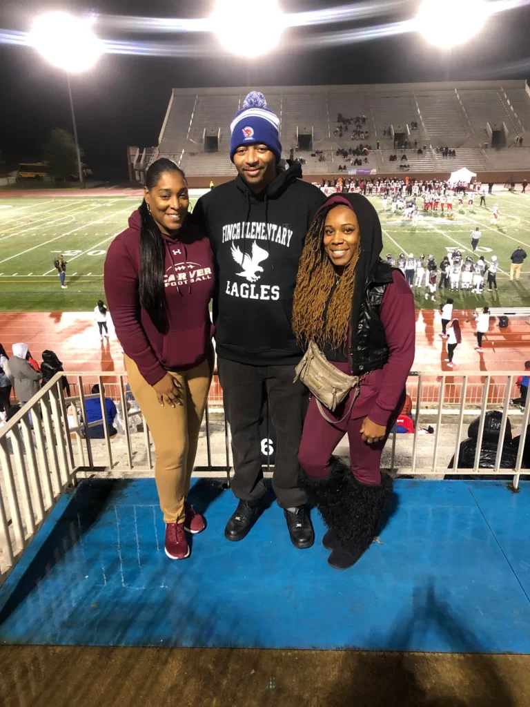 Attending a feeder high school football game with fellow educators. From left to right: Christina Rogers (HS Principal), Gerald, Doretha Johnson (P.E. Paraprofessional).